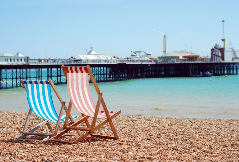 deckchairs on Brighton beach next to the pier